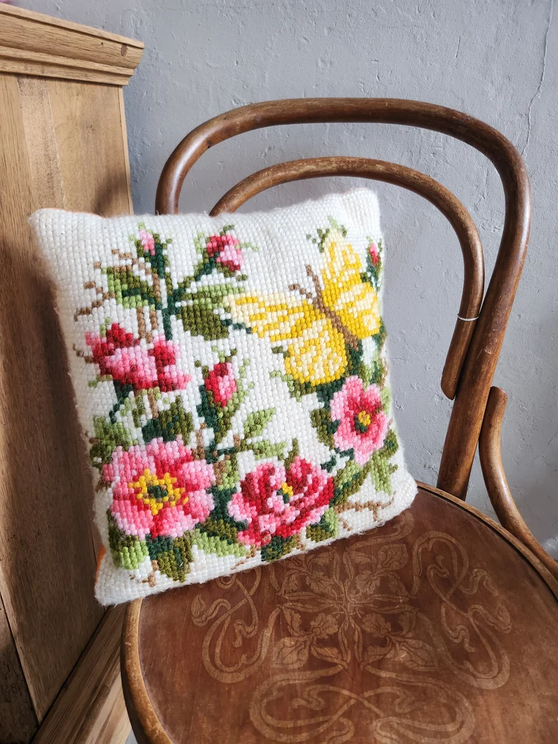 Coussin en point de croix motif fleurs papillon